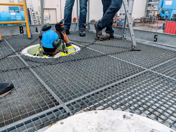 Een collega zakt veilig in een mangat van een besloten ruimte