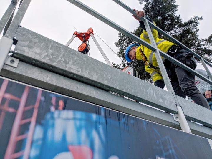 Een collega laat iemand veilig zakken in een mangat van een besloten ruimte