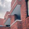 Een detailbeeld langs een zijgevel van een gebouw met rode gevels in De Boterton in Lier | DCA Bouw