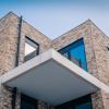 Een detailbeeld van de terrassen aan een gebouw met grijs-gele gevelsteen van De Boterton in Lier | DCA Bouw